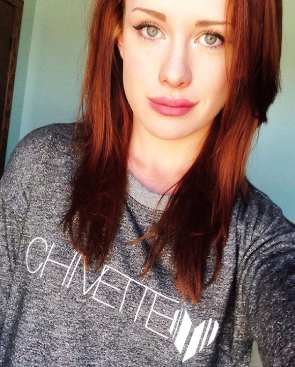 Redhead with cat eyes and plump lips takes selfie in silvery-grey 'Chivette' tee