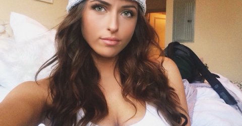Hazel eyed pretty girl wearing a woolen cap looking for a selfie with a calm eyes