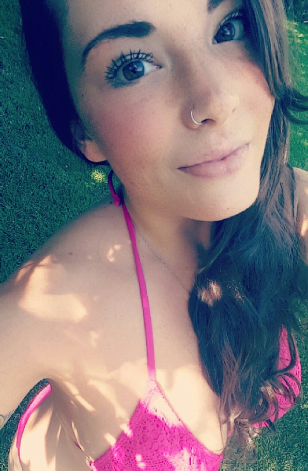 Blue eyed girl wearing a pink bikini clicks a selfie from the top of her head