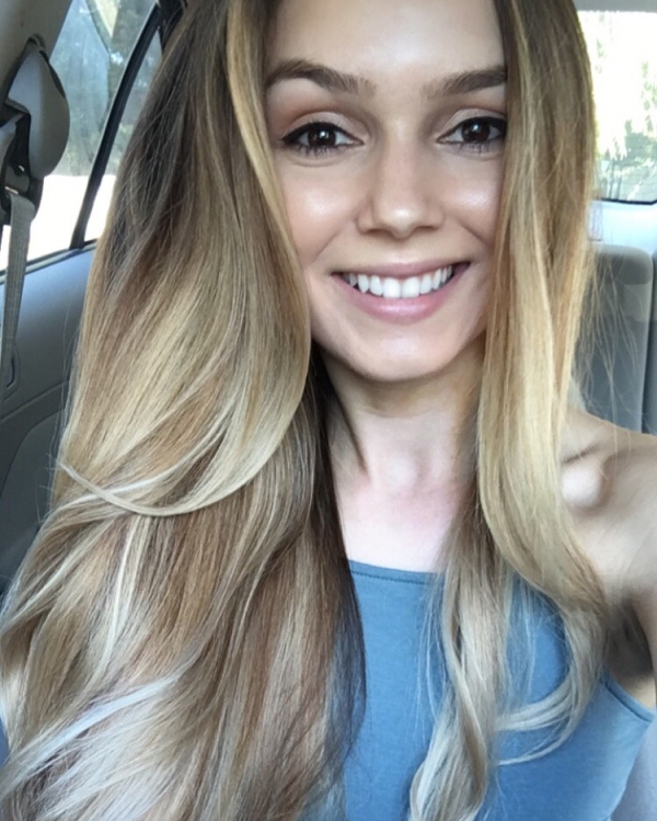 Cute girl smiling in this car selfie wearing a blue top