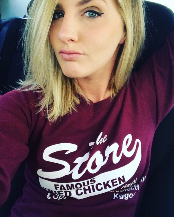 Blonde with blue eyes and full lips takes selfie in violet tee