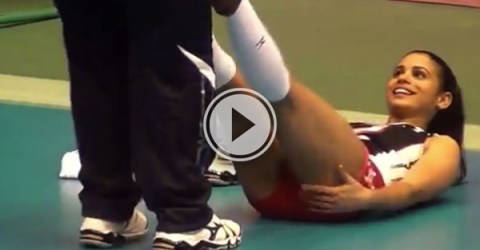 Physio helps the female athlete with stretching while she is lying on the court (Video)