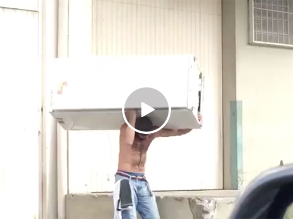 Man carries fridge while biking